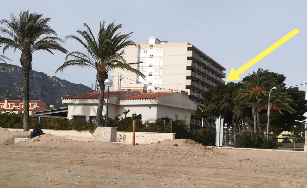 a building and palm trees in front of a building at Apartamento con vistas, entre mar y montaña in Hospitalet de l'Infant