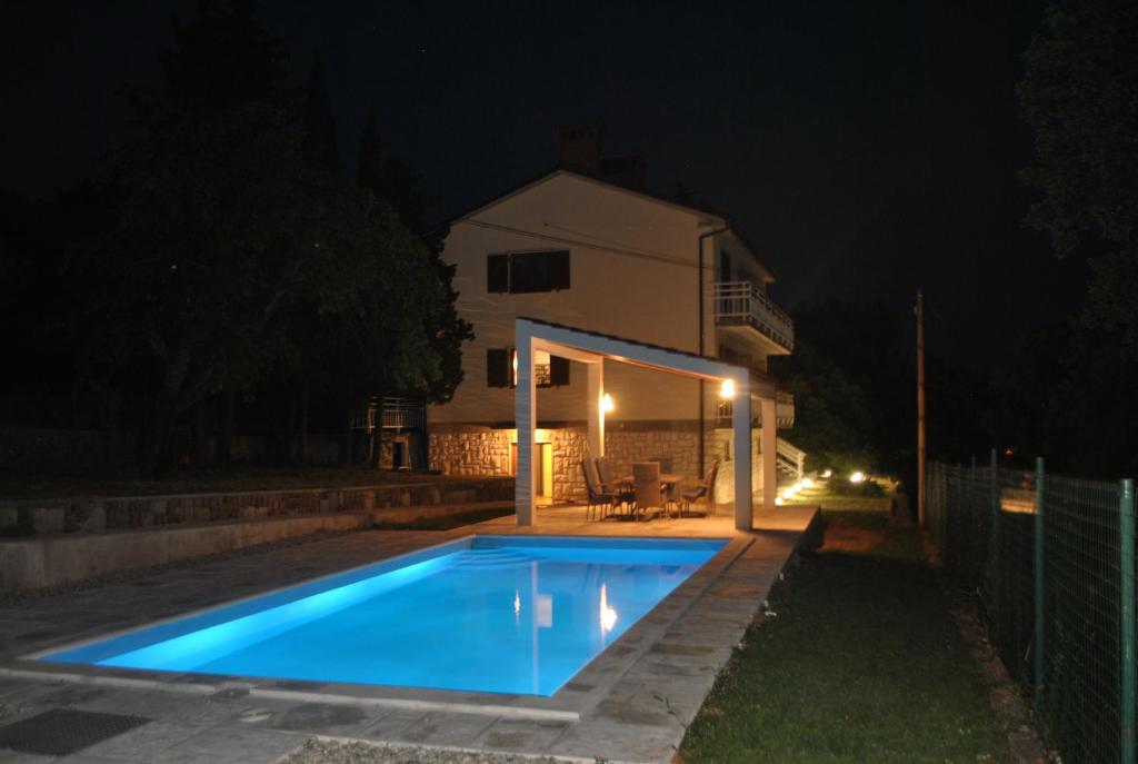 a swimming pool in front of a house at night at Villa Rožica in Rijeka