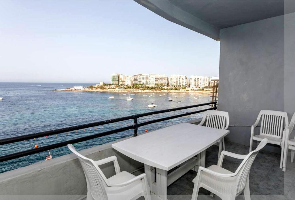 d'une table et de chaises sur un balcon donnant sur l'océan. dans l'établissement St Julians' Sea Front, Spectacular View, Apartment, à San Ġiljan