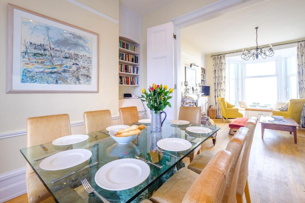 a dining room with a glass table and chairs at Gunfleet, Aldeburgh - A Large Seafront House with Stunning Sea Views from all the floors, Sleeps 14 - Aldeburgh Coastal Cottages in Aldeburgh