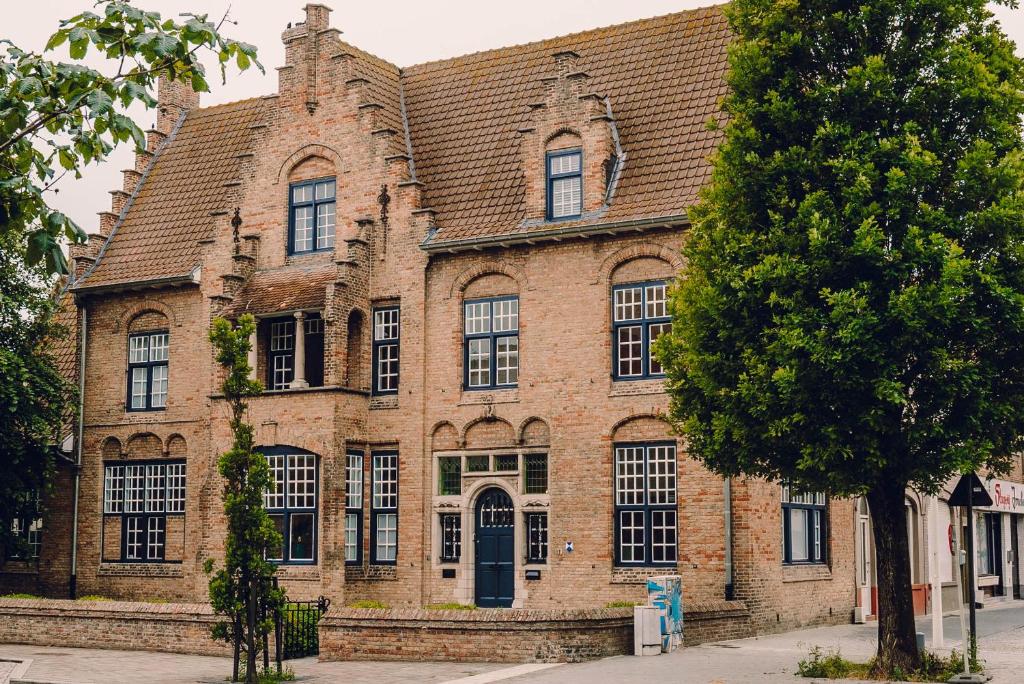 un grand bâtiment en briques avec un toit brun dans l'établissement Blauwe Huis B&B, à Nieuport