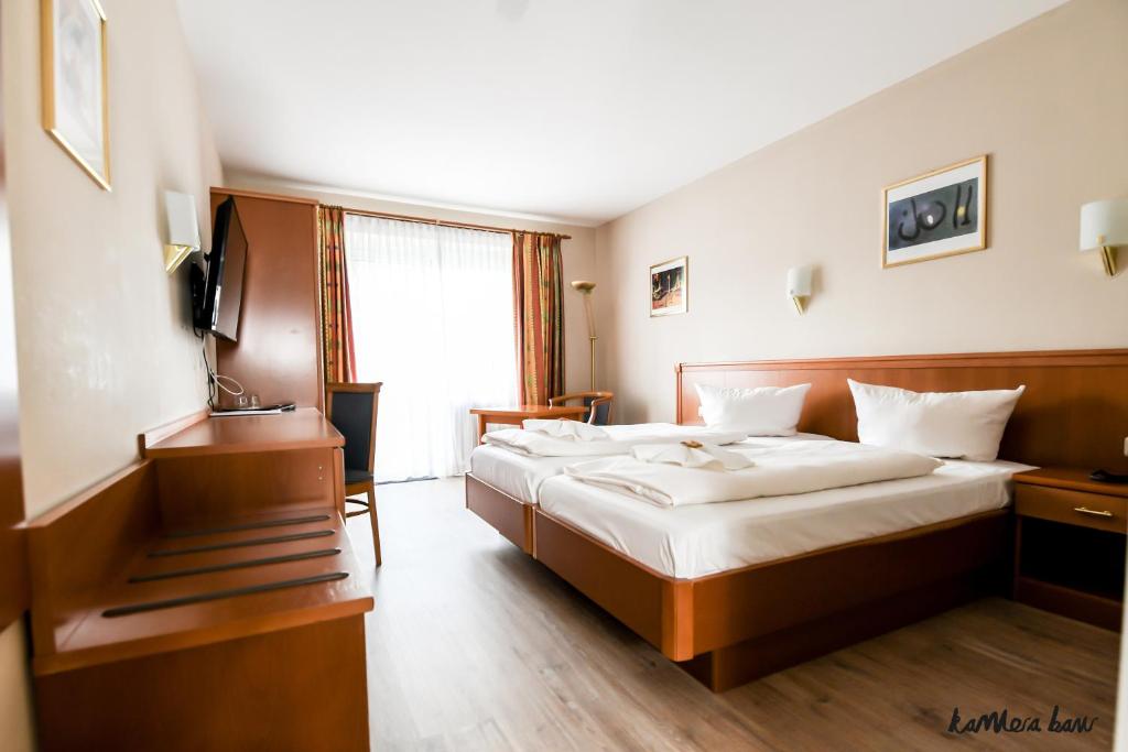 um quarto de hotel com uma cama e uma televisão em Hotel Blutenburg em Munique