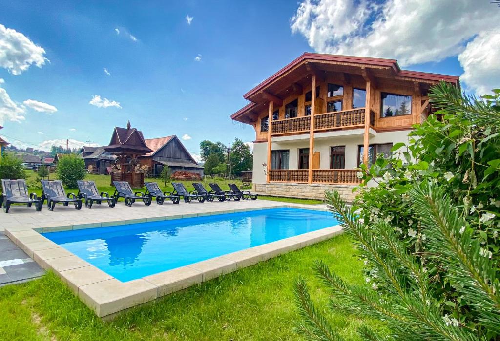 a house with a swimming pool in the yard at Apartments Chalet Girska Hatyna in Vorokhta