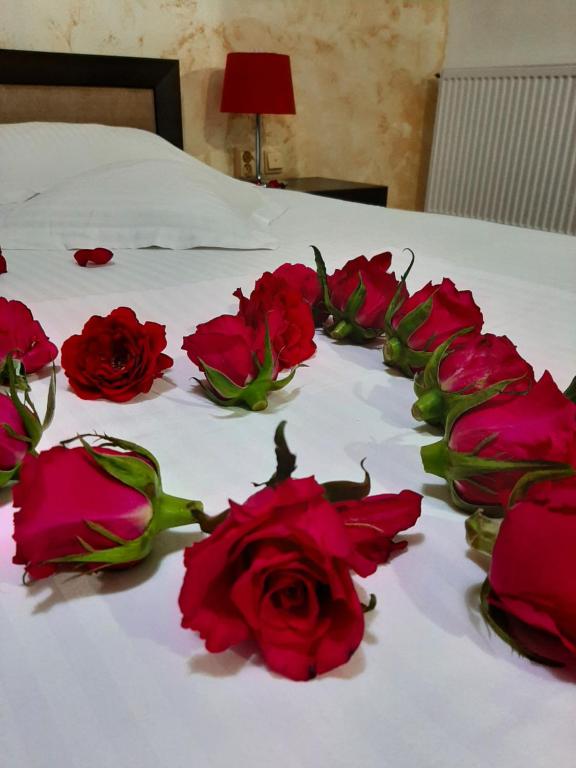 a group of red roses on a bed at Pensiunea Caramell in Cluj-Napoca