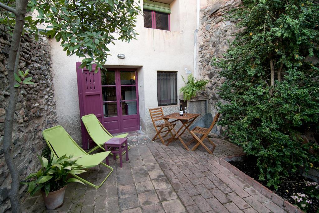 Porrera的住宿－LA CASETA DEL PRIORAT II，庭院设有紫色的门、椅子和桌子