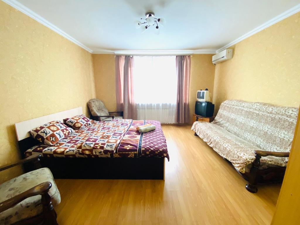 アルマヴィルにあるCity Apartment Sverdlova 71のベッドルーム1室(ベッド1台、ソファ、窓付)