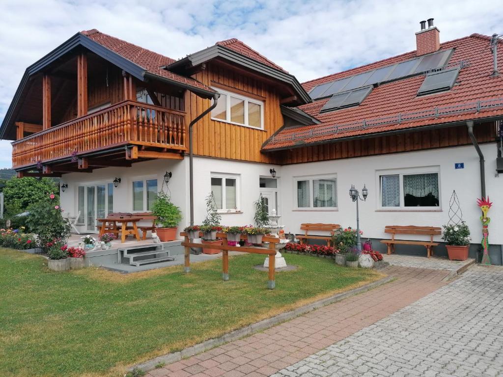 uma casa com varanda e bancos no quintal em Ferienwohnung Liskowetz em Lambichl