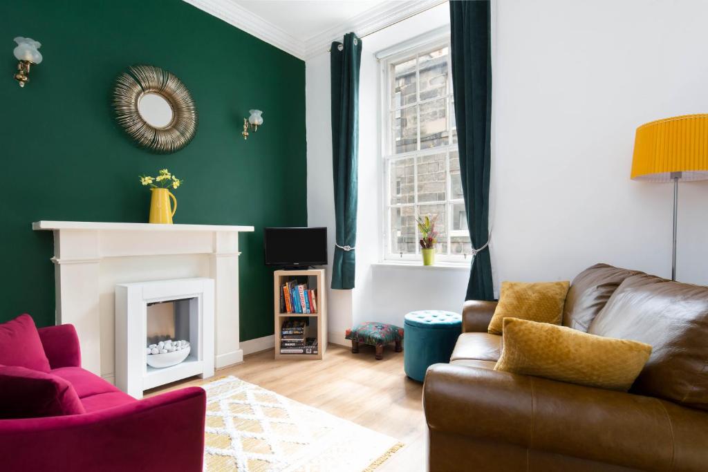 a living room with a couch and a fireplace at Stockbridge Two Bedroom Apartment in Edinburgh