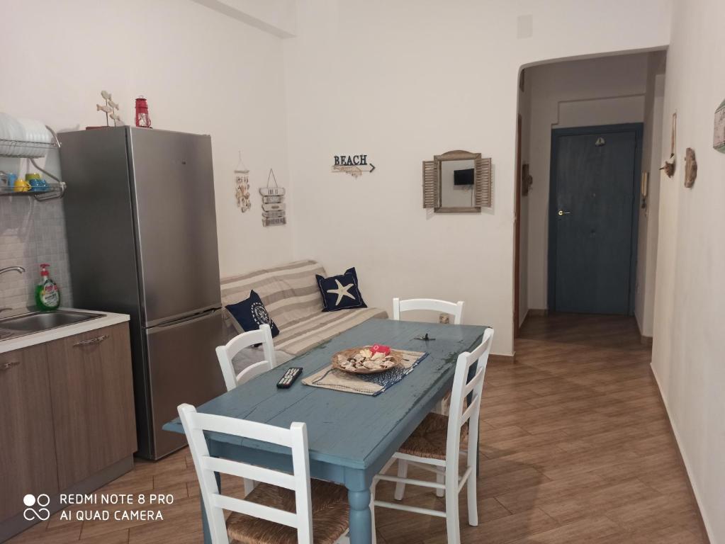 a kitchen with a blue table with chairs and a refrigerator at Casa Sferracavallo in Sferracavallo