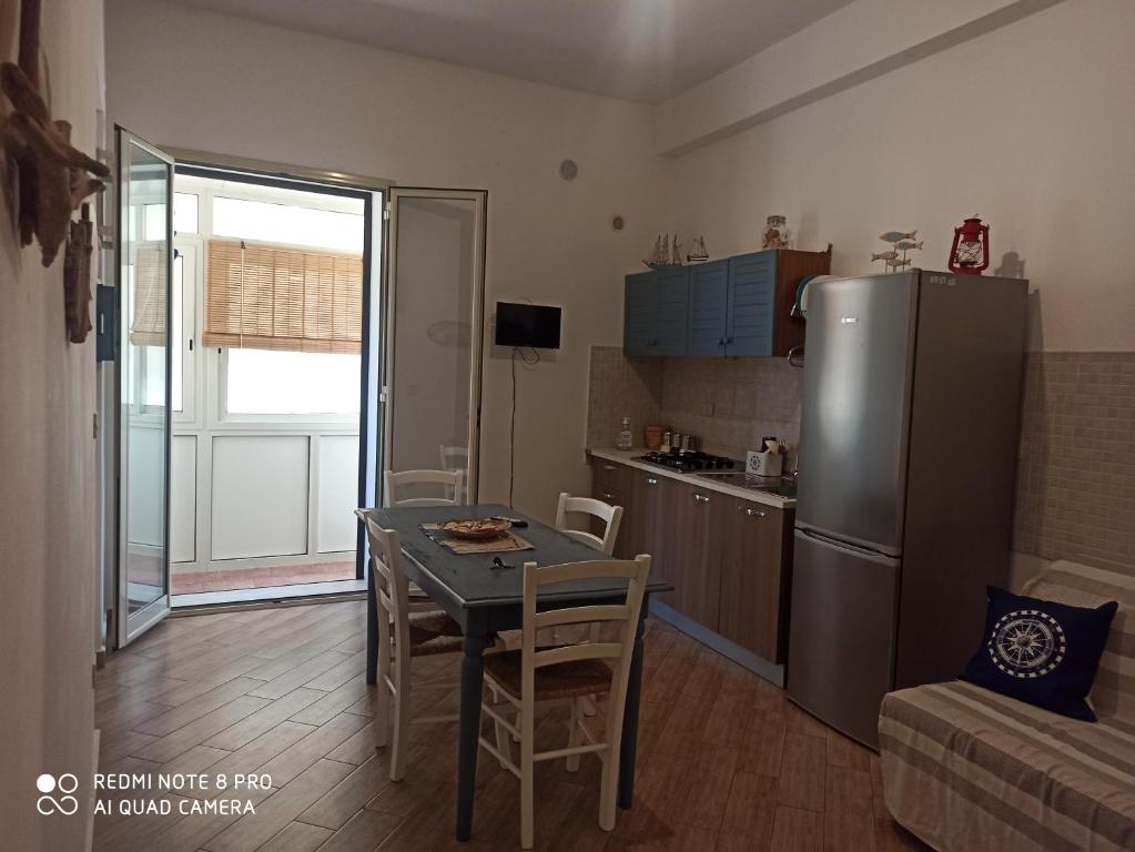 kuchnia ze stołem i lodówką ze stali nierdzewnej w obiekcie Casa Sferracavallo w mieście Sferracavallo