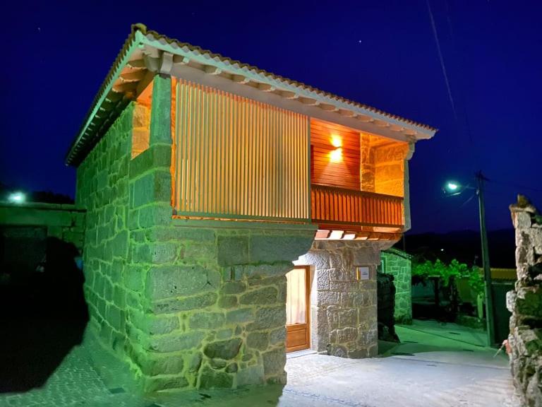 - un bâtiment en briques avec un balcon la nuit dans l'établissement CASA DA ESCOLA, à Lobios