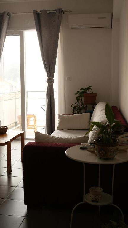 a bedroom with a bed and a table and a window at B2 - The cozy one in Aigio