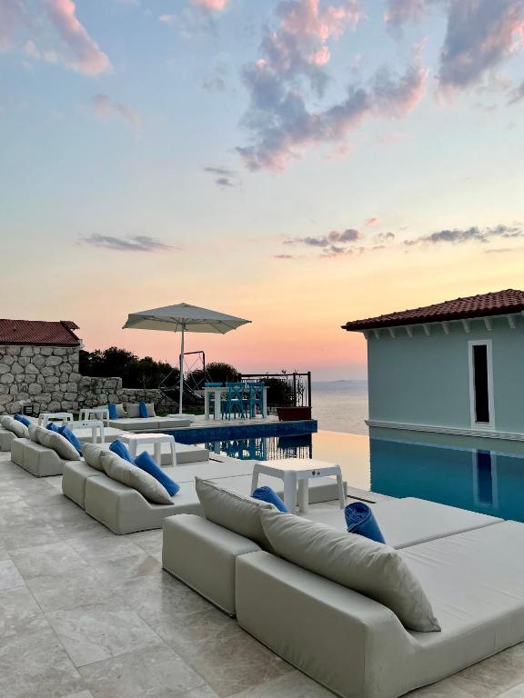 a row of white couches on a patio overlooking the ocean at Gümüş Yazar Hotel in Kaş