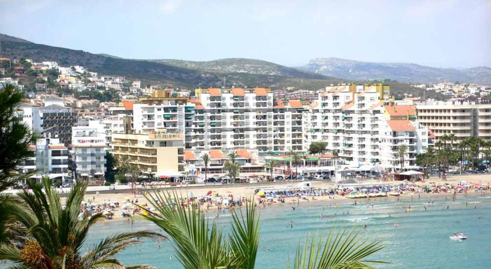 a beach with a bunch of people in the water at Peñiscola Playa Orangecosta in Peniscola