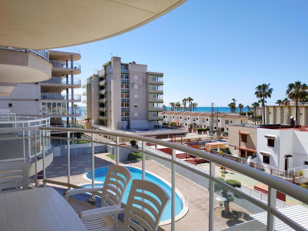 a balcony with chairs and a pool and buildings at La Volta II Orangecosta in Peniscola