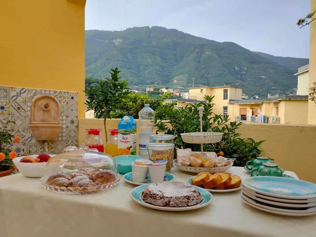 een tafel met borden eten erop met een berg bij B&B Il Vialetto in Castellammare di Stabia