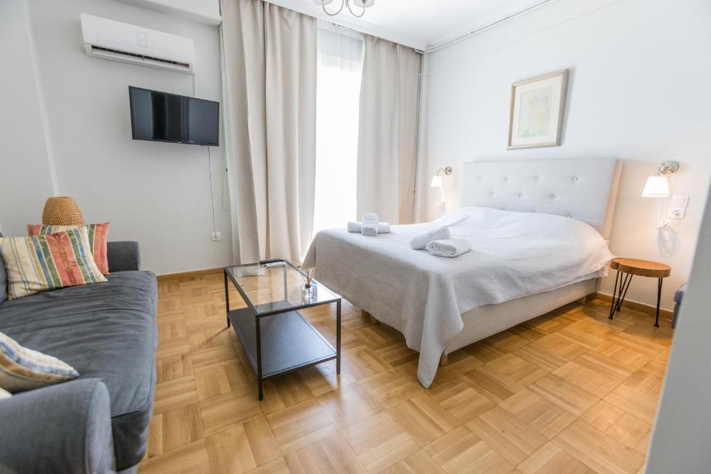 um quarto com uma cama e uma sala de estar com um sofá em Filoxenia MG Kolonaki Athens em Atenas