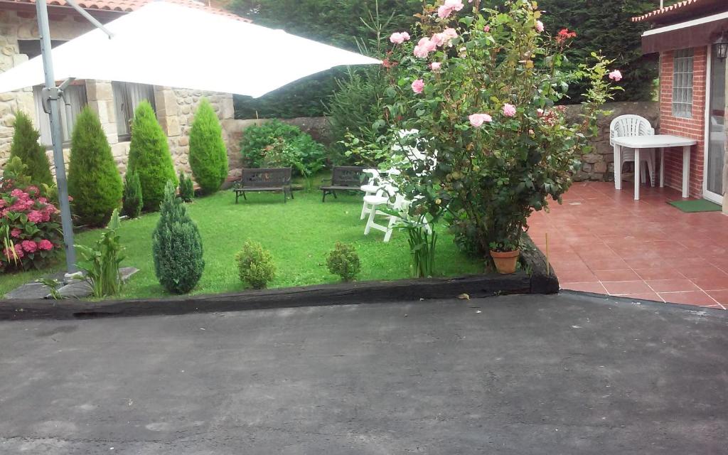 a garden with flowers and plants and an umbrella at playa y montaña in Cabezón de la Sal