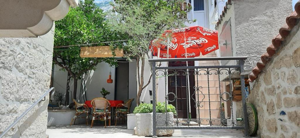 a patio with an umbrella and a table and chairs at Apartman Karla in Makarska