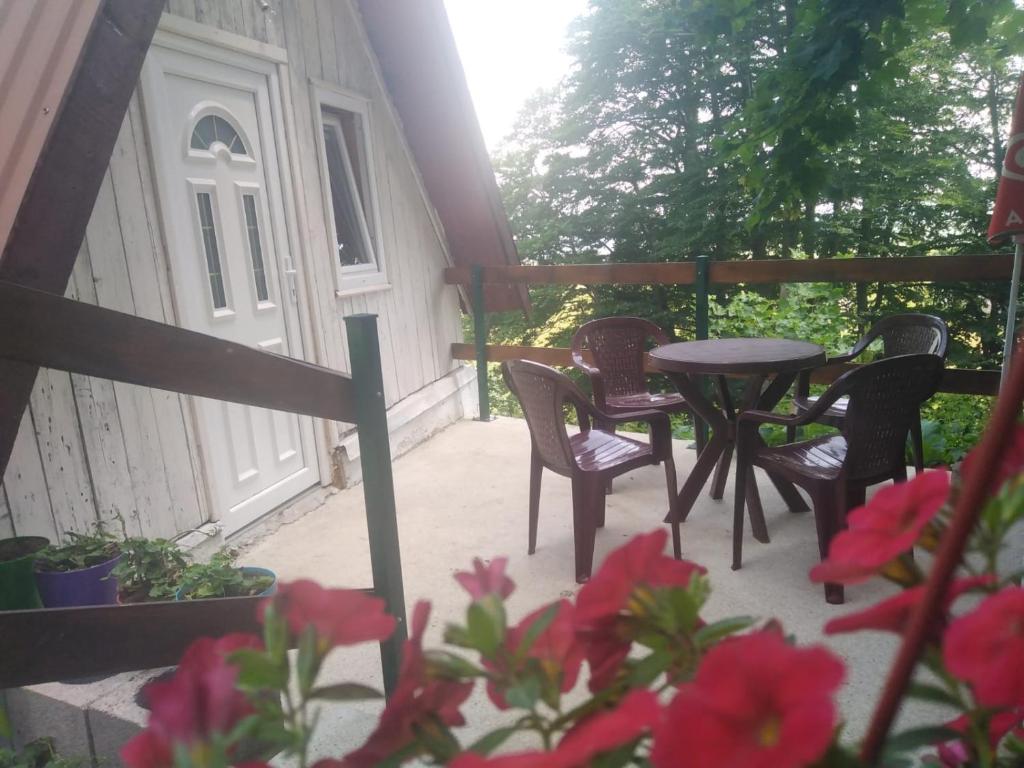 a porch with a table and chairs and flowers at Dobre Vode 2 in Žabljak
