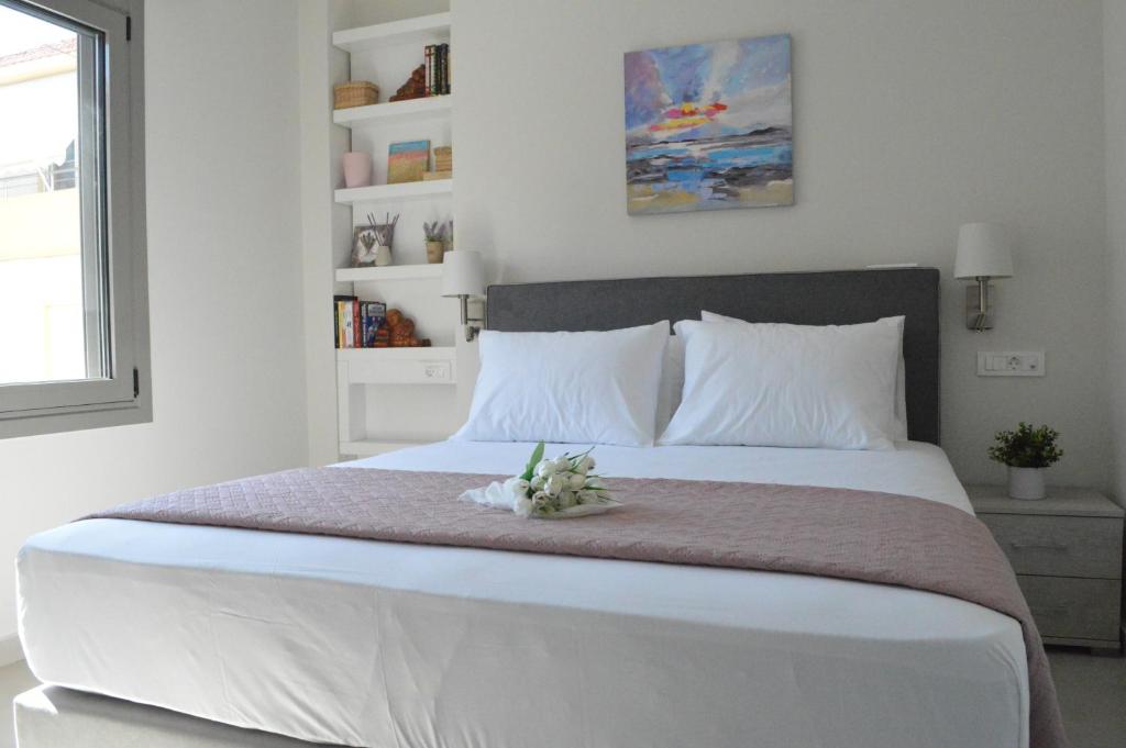 a bedroom with a large white bed with flowers on it at Leonidas House in Chania