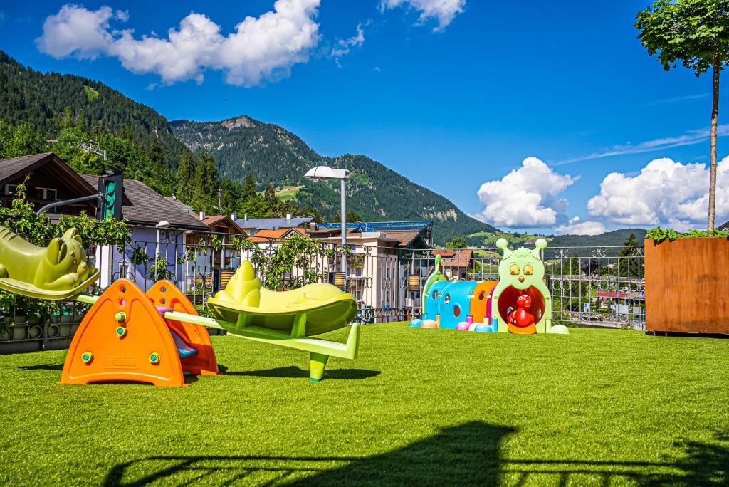 a playground with different types of play equipment on the grass at Hotel Garni Snaltnerhof in Ortisei