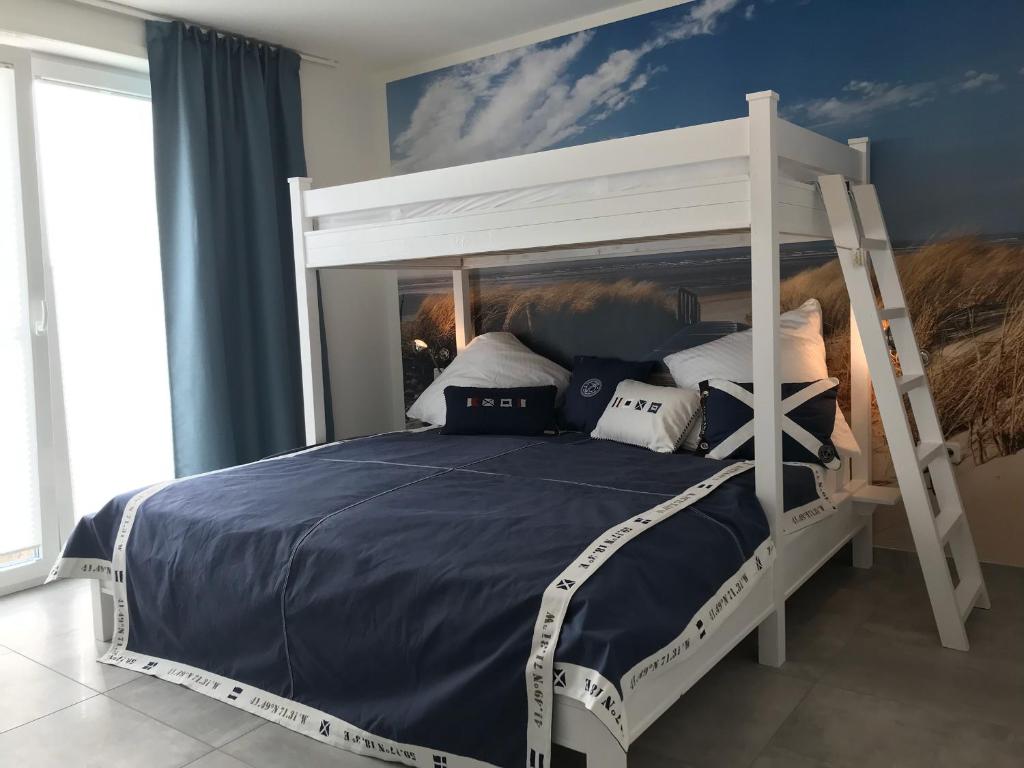 a bedroom with a bunk bed with blue walls at OceanView in Wittdün