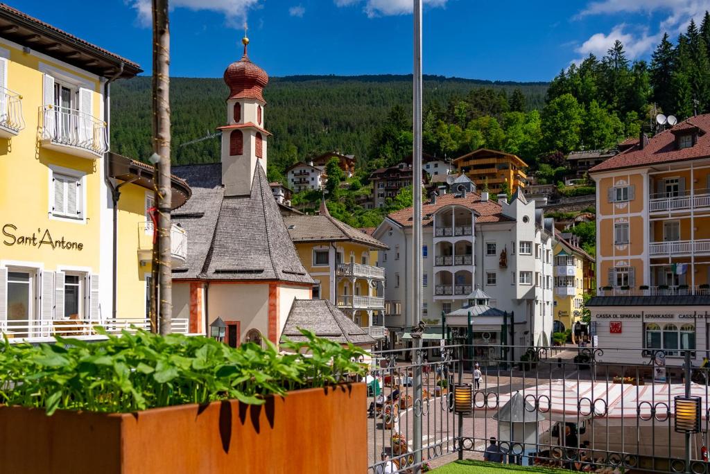 a view of a town with a clock tower at Hotel Garni Snaltnerhof in Ortisei