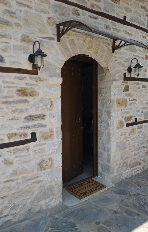 a door in a stone wall with two lights at Μountain Whispers in Mouresi