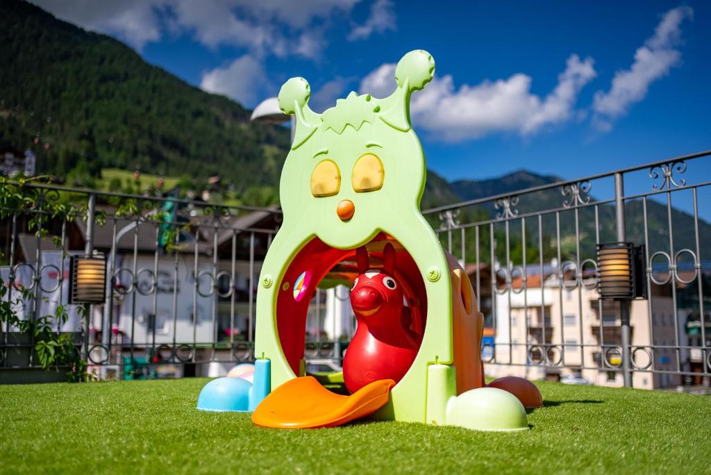 a playground with a toy in the grass at Hotel Garni Snaltnerhof in Ortisei