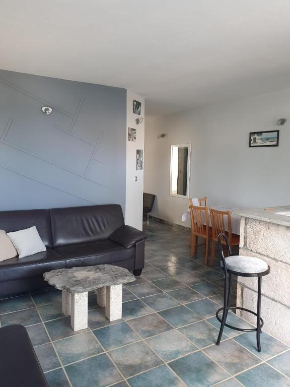 salon z czarną kanapą i stołem w obiekcie Apartmani Huljić w mieście Stari Grad