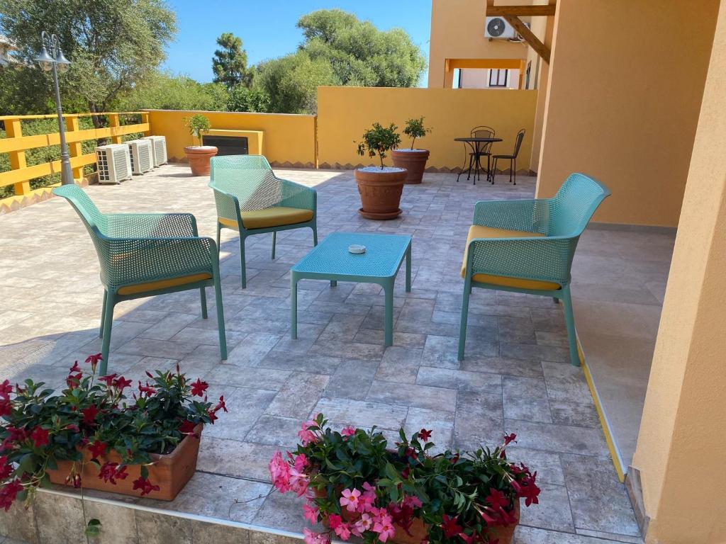 eine Terrasse mit Stühlen, einem Tisch und Blumen in der Unterkunft B&B Pettirosso in San Teodoro