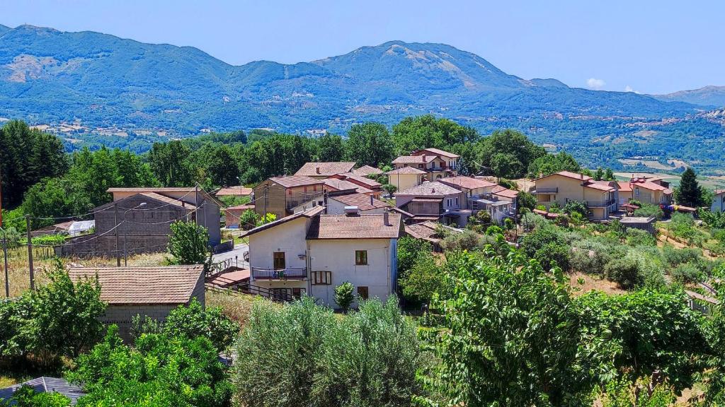 a village on a hill with mountains in the background at Tana di Zia Nature, Yourself, Love in Viggianello