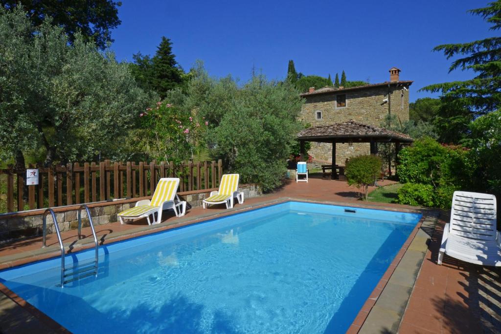 einen Pool mit zwei Stühlen und einem Pavillon in der Unterkunft Casa Citille in Greve in Chianti