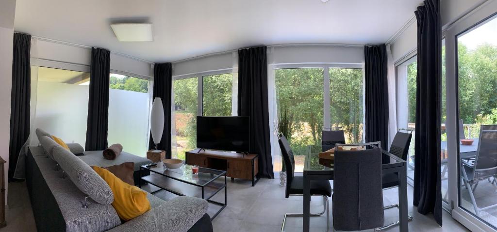 ein Wohnzimmer mit einem Sofa und einem TV in der Unterkunft Firmen & Ferienwohnung Brecht 2 in Waibstadt