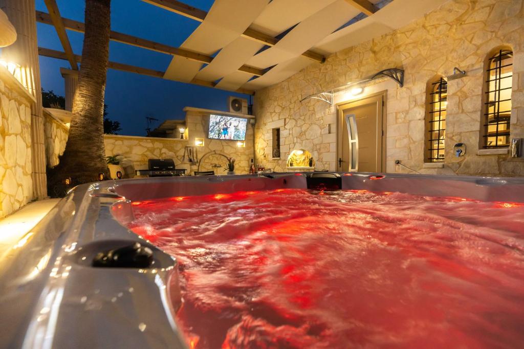 una grande vasca da bagno riempita di liquido rosso di Villa Vlite a Souda (Suda)