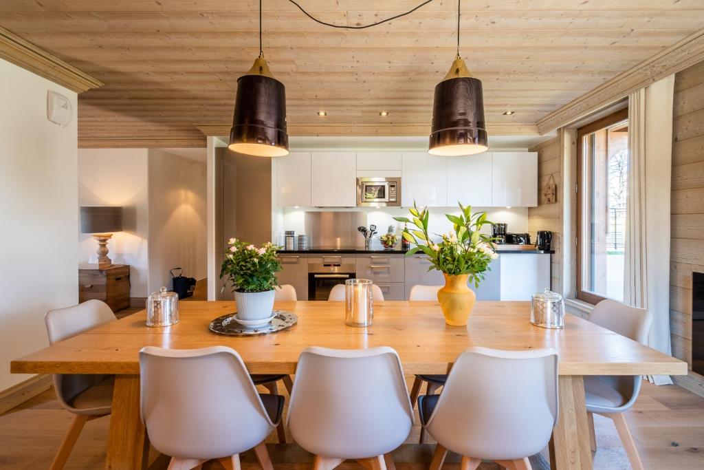 a dining room with a wooden table and chairs at AUx SPORTS D HIVER in Courchevel