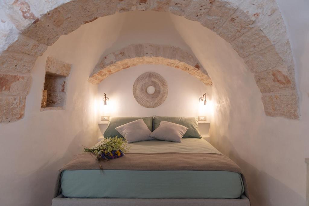 a bed in a room with an arched ceiling at Trulli Magheia in Alberobello