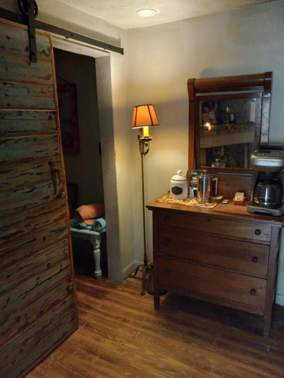 a room with a dresser and a lamp and a door at Funny Farm in Saint Augustine