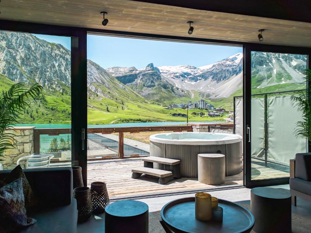 een kamer met een bad en uitzicht op een berg bij Langley Hôtel Tignes 2100 in Tignes