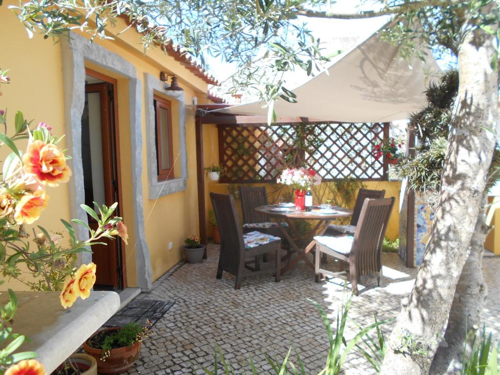 a patio with a table and chairs and a fence at Casa da fonte in Salir de Porto