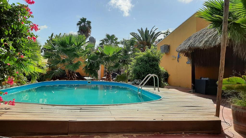 a swimming pool on a wooden deck next to a house at B&B Casa Trankilo in Kralendijk