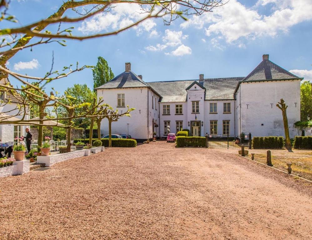 una imagen de una gran casa blanca con entrada en B&B Kasteel Baexem, en Baexem