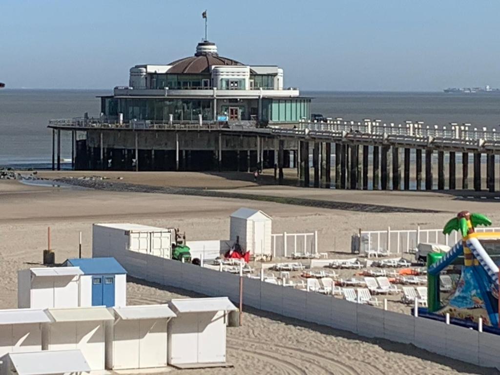 a beach with a pier and a building at Apartment Seadream in Blankenberge