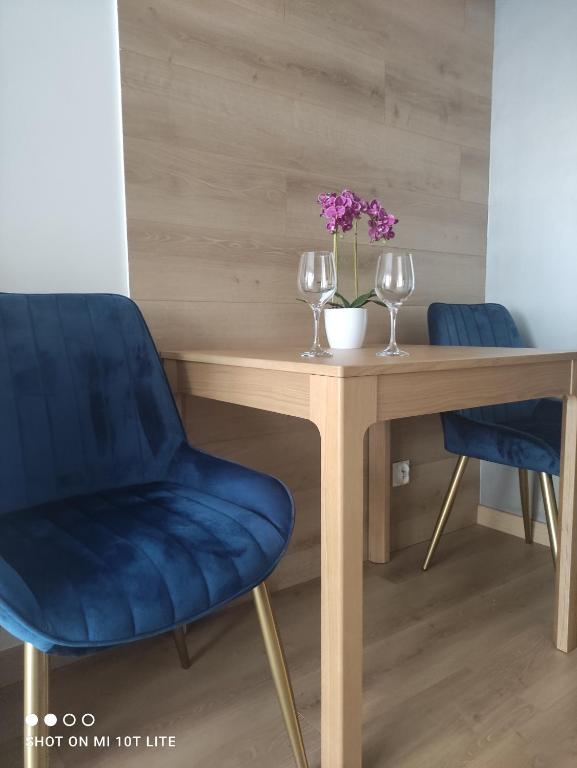 stół z 2 krzesłami i 2 kieliszkami do wina w obiekcie Perła Apartament Mińsk w mieście Mińsk Mazowiecki