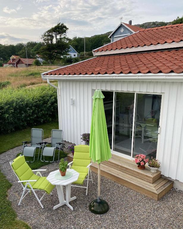 a patio with chairs and an umbrella and a table at Nösund Guestroom in Nösund