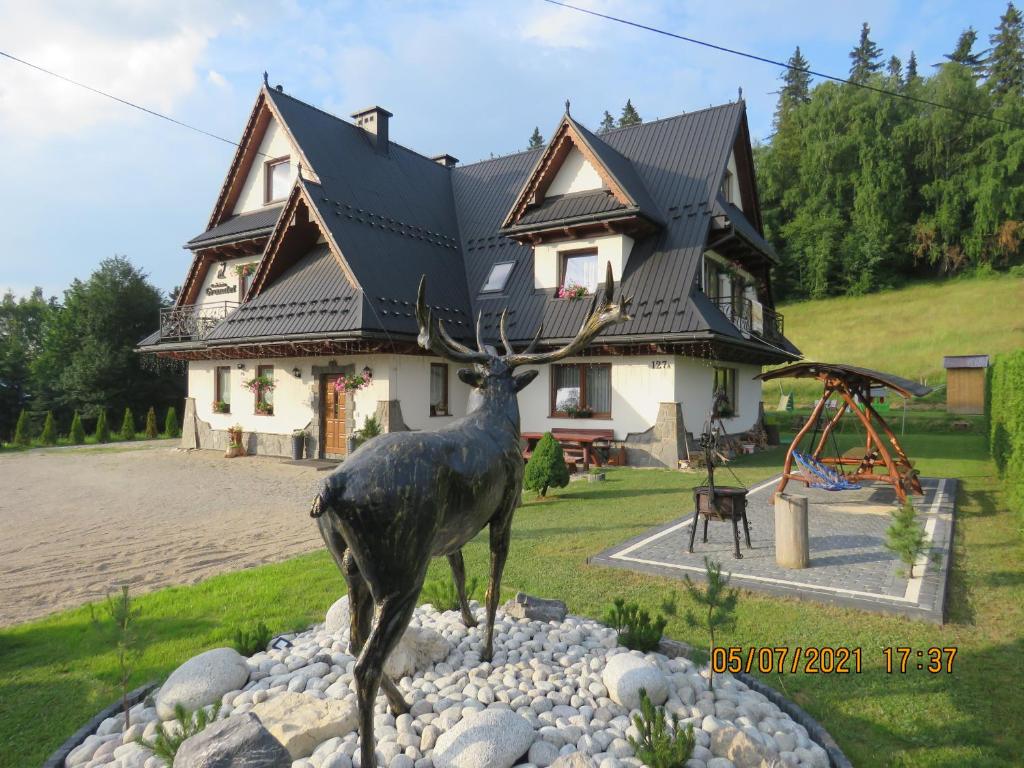 a statue of a deer in front of a house at Gościniec Grandel in Bukowina Tatrzańska