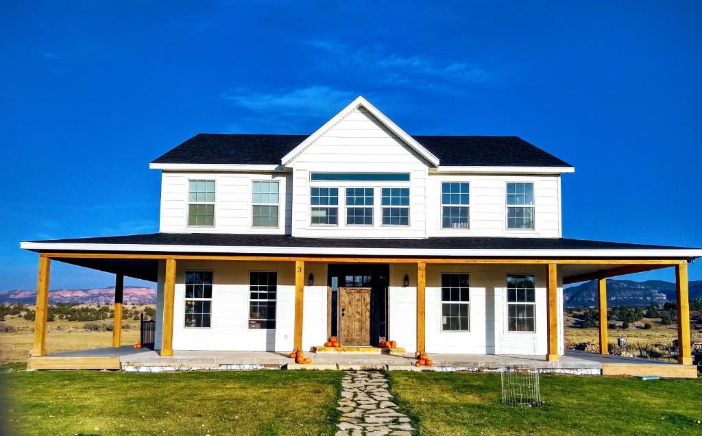 una casa blanca con techo negro en Sevier River Farmhouse 1, en Hatch