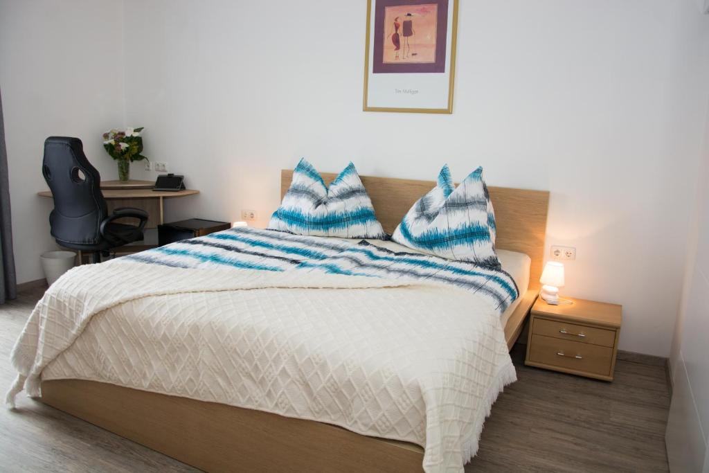 um quarto com uma cama com lençóis azuis e brancos em Helis Gästezimmer em Kirchbach in Steiermark