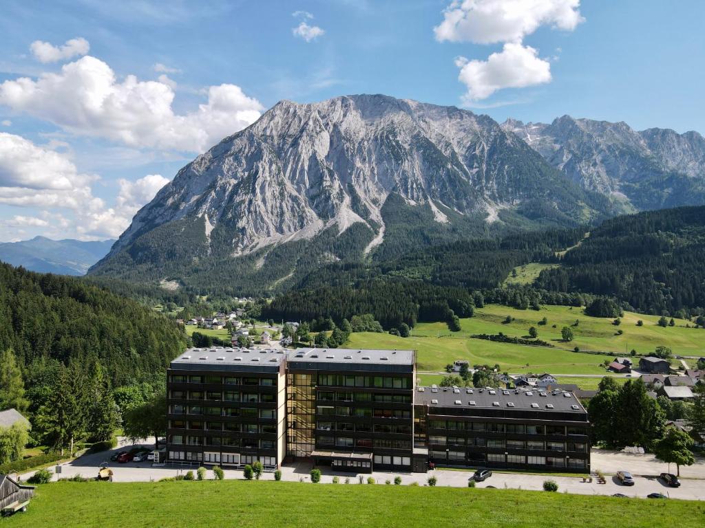 ein Gebäude auf einem Feld mit einem Berg im Hintergrund in der Unterkunft Ferienwohnung Chrisi im Kulmhof in Tauplitz